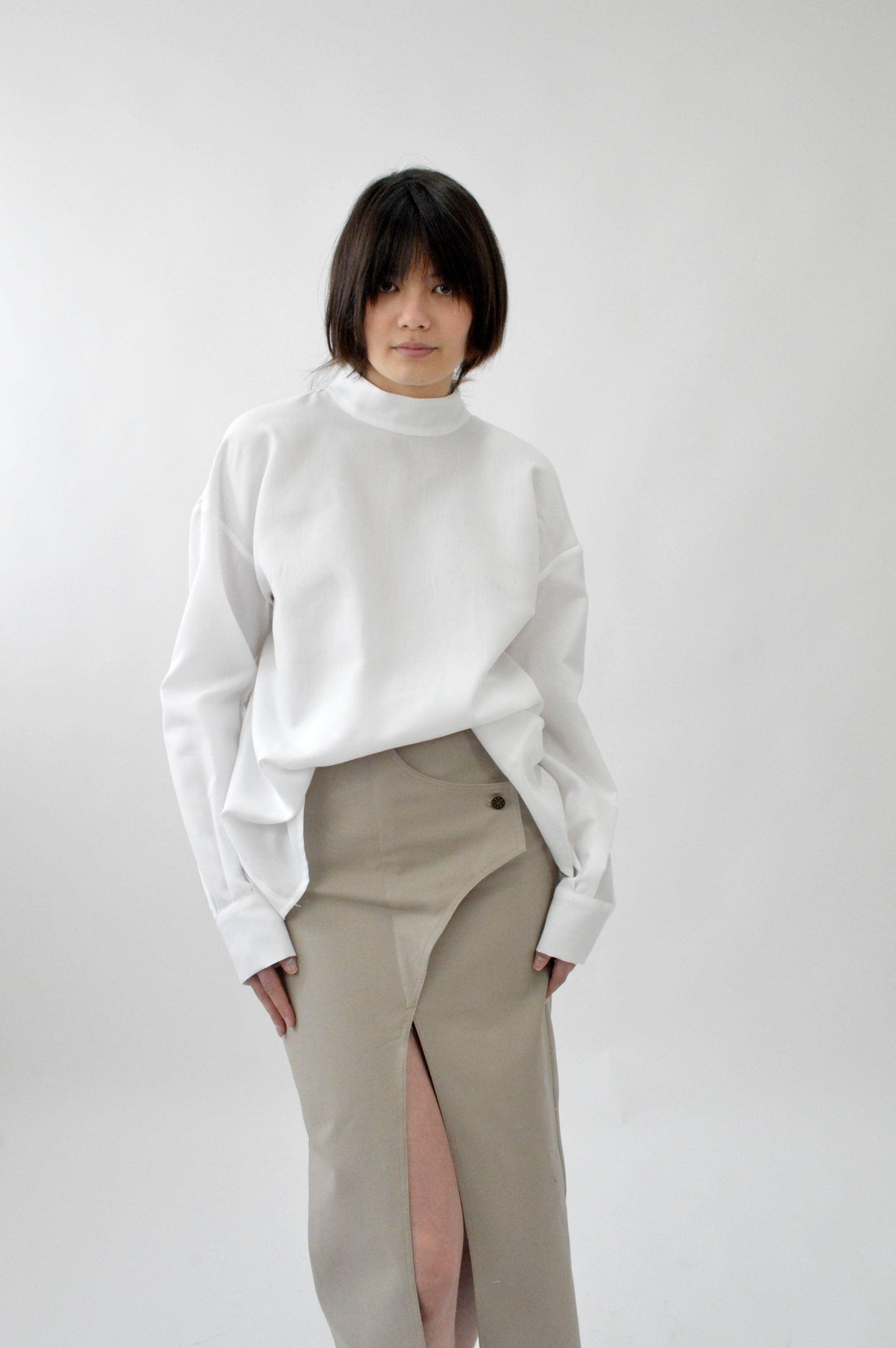 Femme portant la CHEMISE TELAMON, col mao, manche longue avec poignet, blanche.