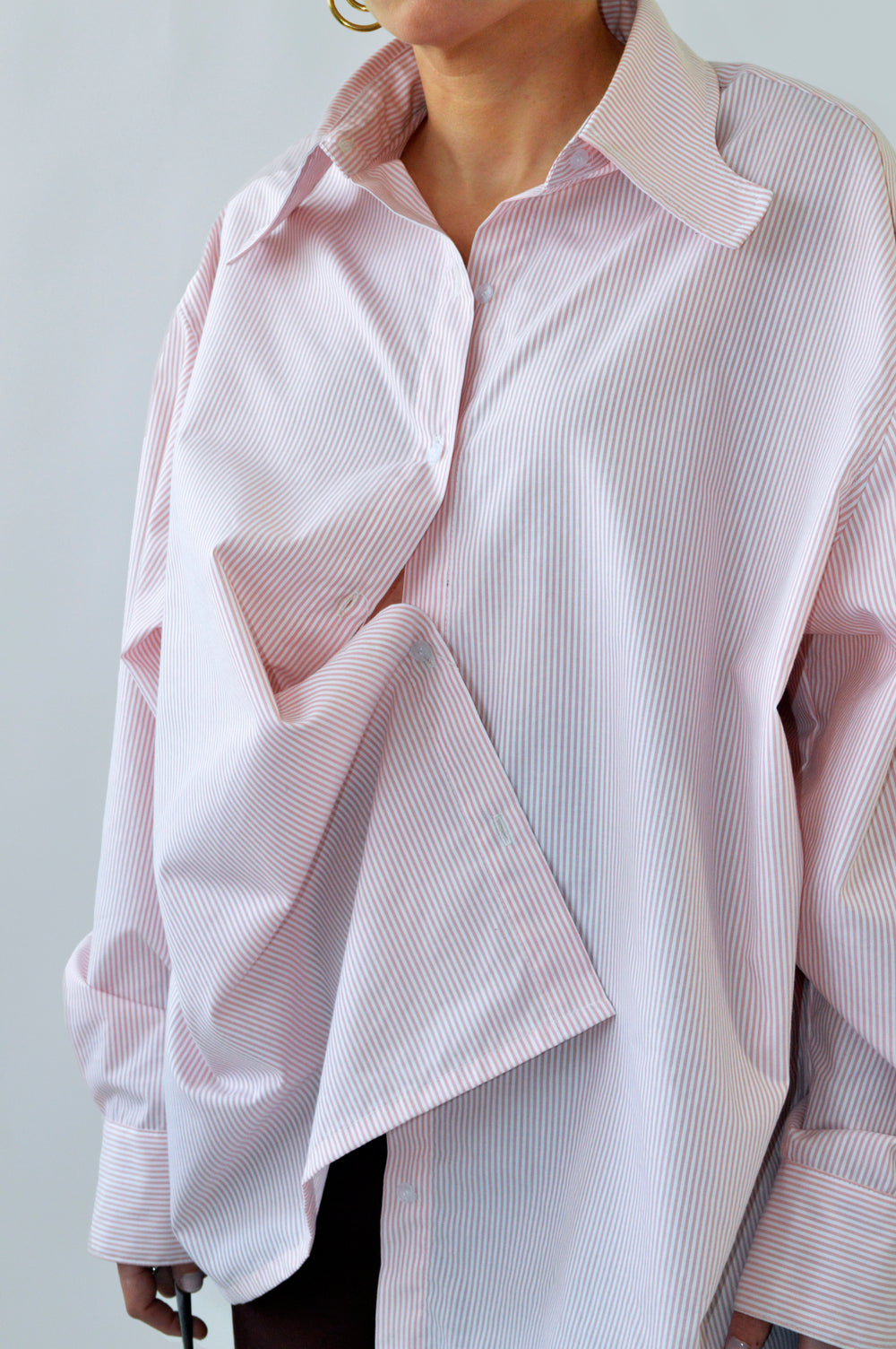 Détail du drapé de la CHEMISE TOC TOC en coton rayé rose et blanc, soulignant sa coupe ample et les plis féminins.
