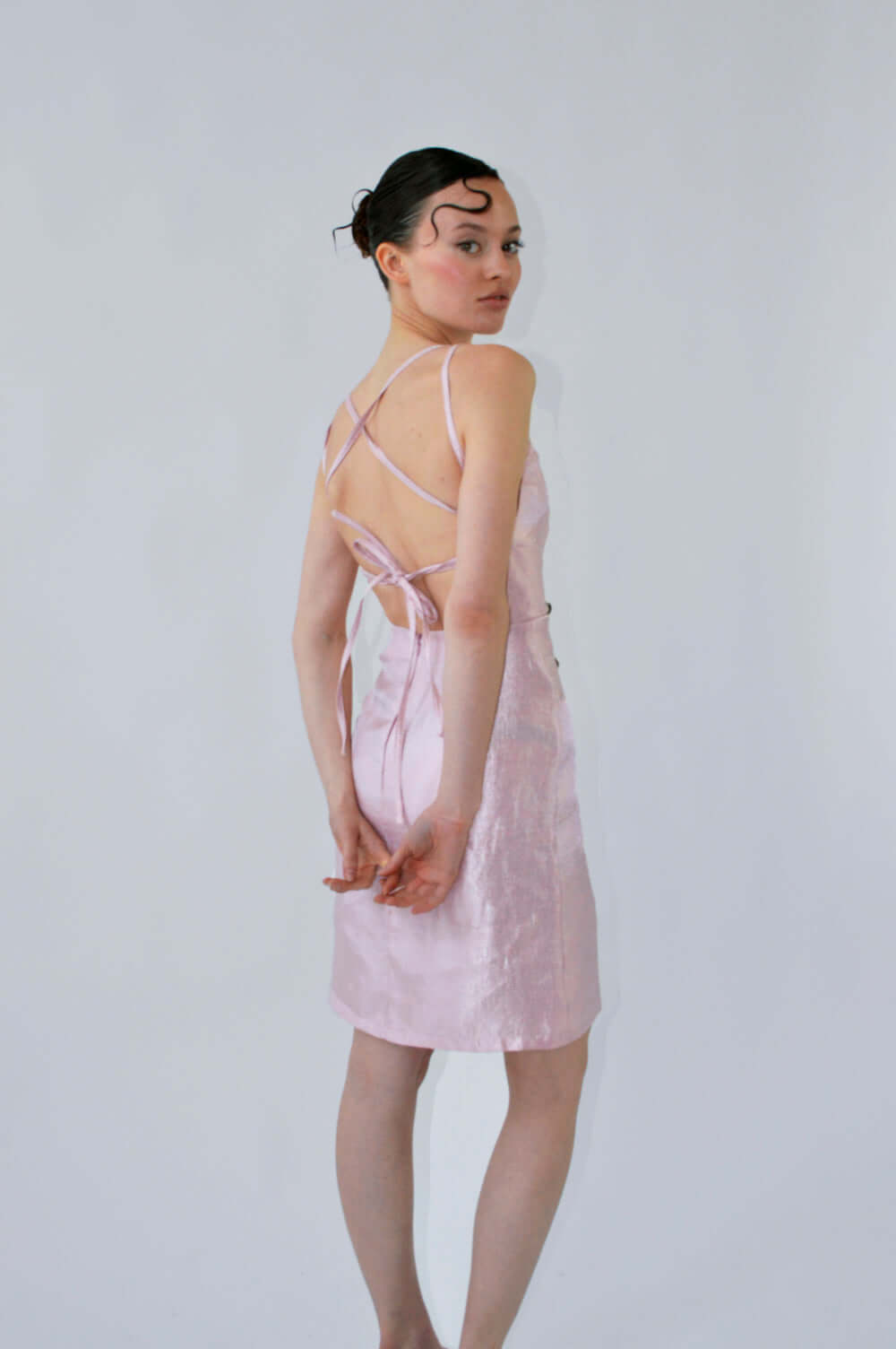 Robe TCHOUKETA rose irisé, vue de dos mettant en valeur les brides croisées et le dos nu ajustable.