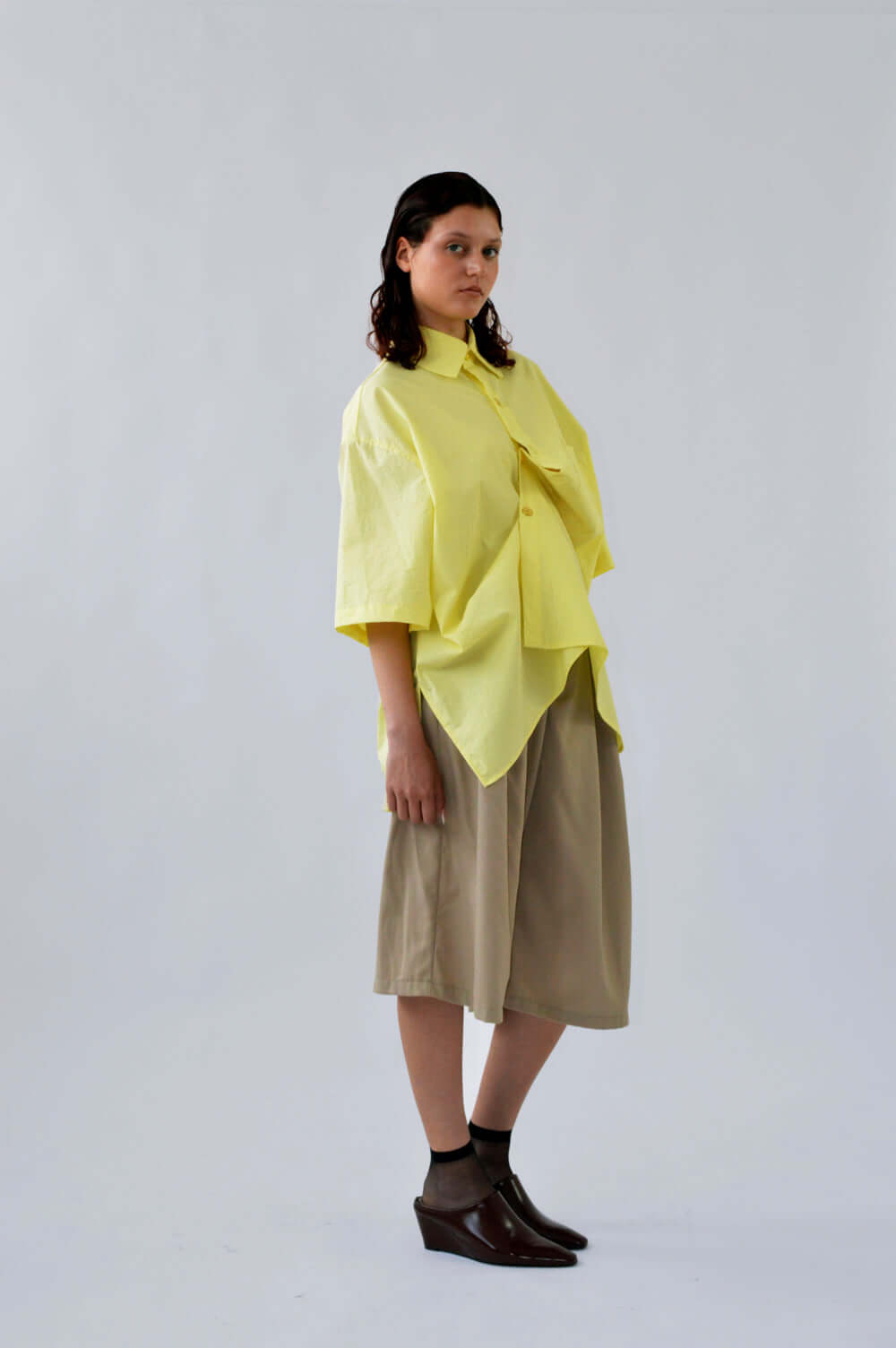 Femme portant le BERMUDA TRALALA SABLE en laine associé avec la chemise PAF JAUNE, coupe structurée et élégante.