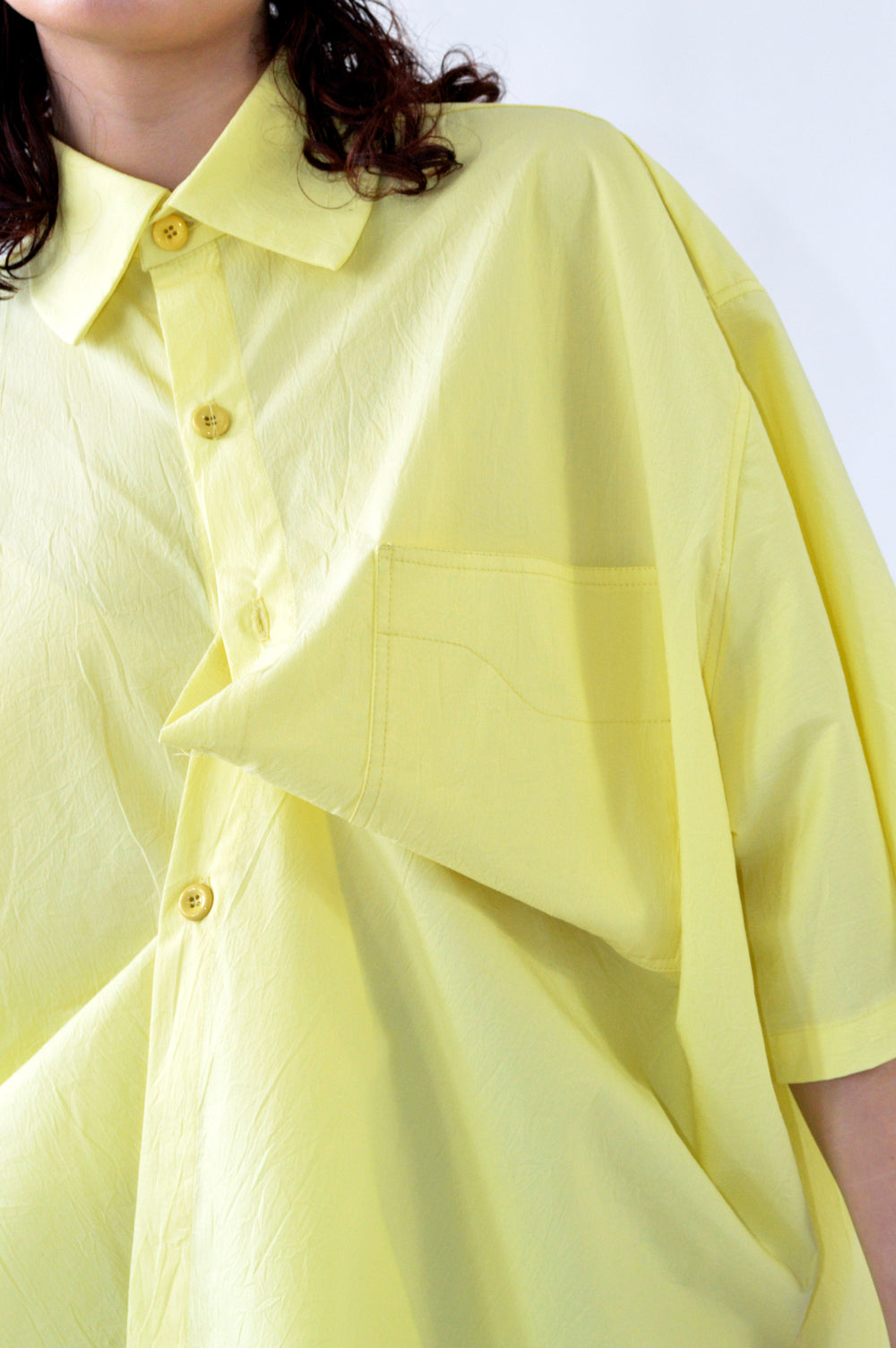 Focus sur le détail de la poche avant, chemise PAF JAUNE, couture en forme de vague, 100% Coton.