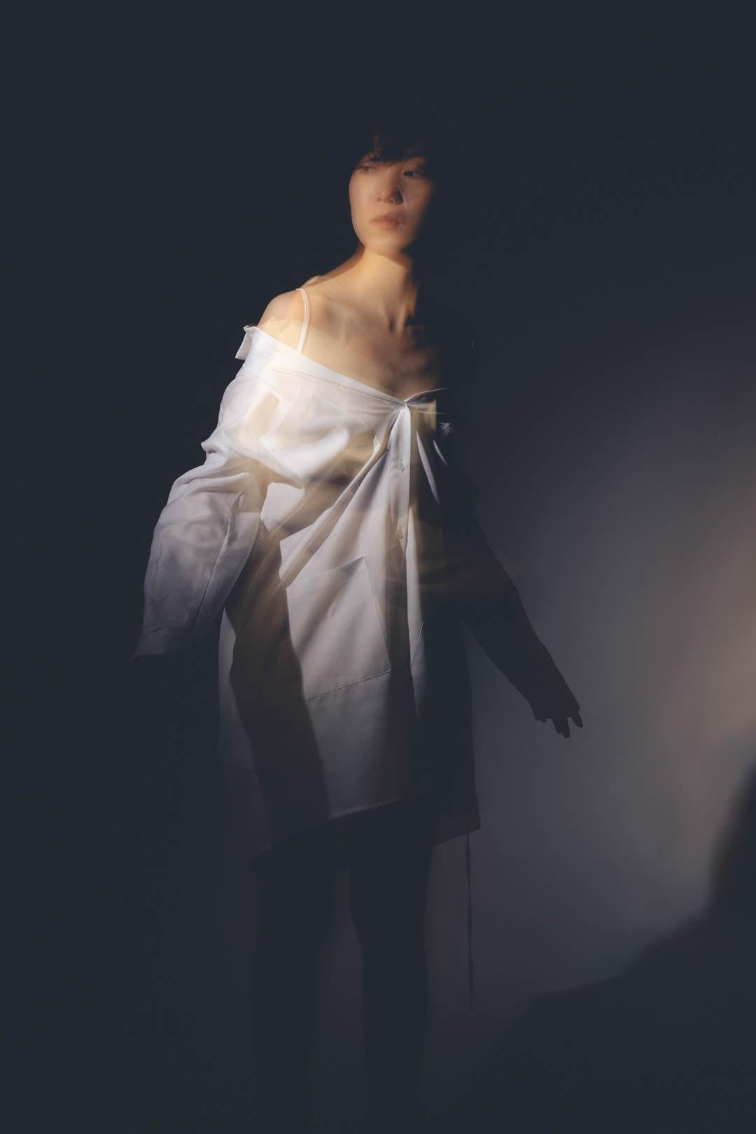 Femme portant la CHEMISE ATLANTE, chemise ouverte, col chemisier sous l'épaule.