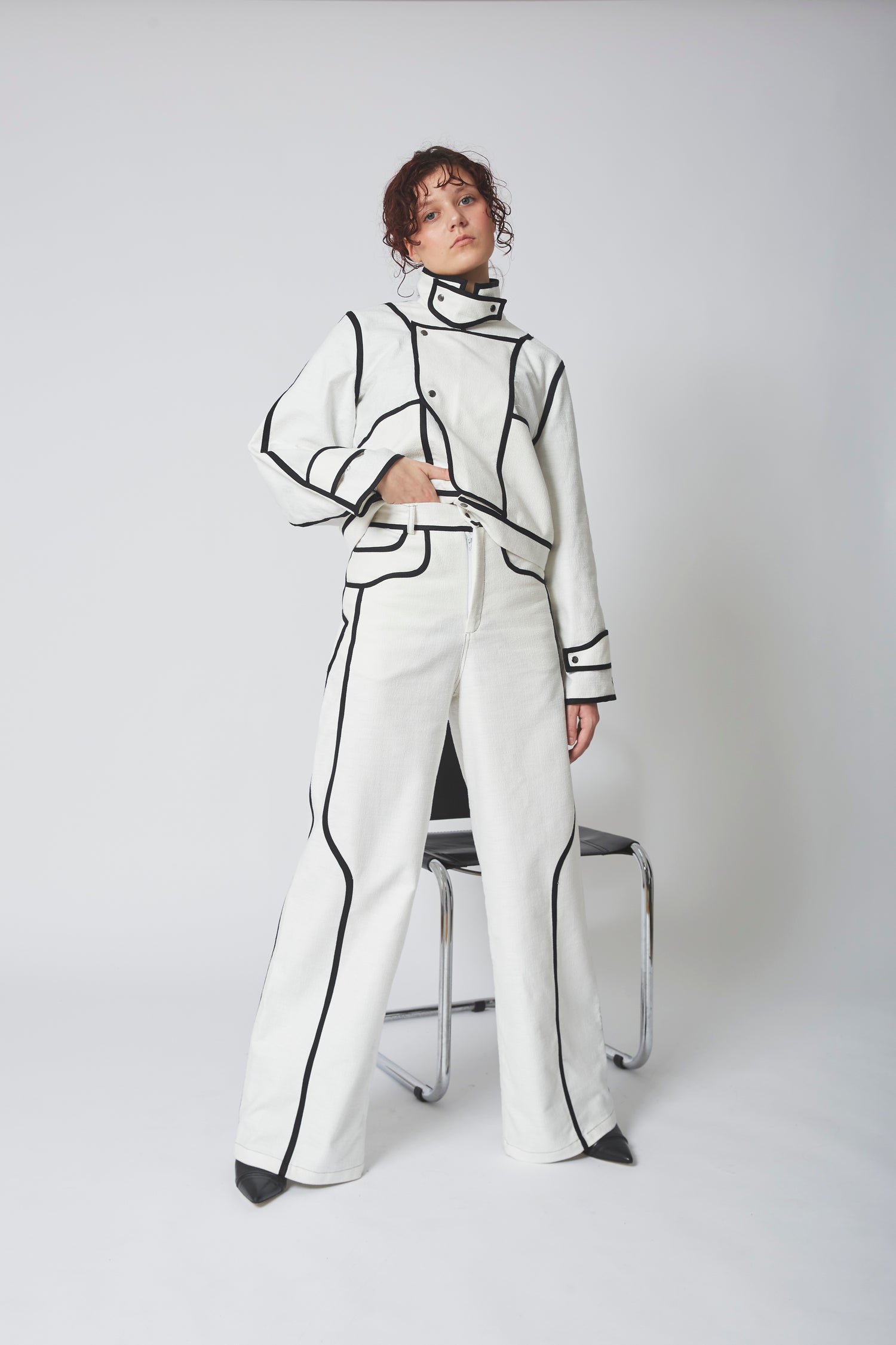 Femme portant le PANTALON BIAIS NOIR, lignes verticales allongeant la silhouette.