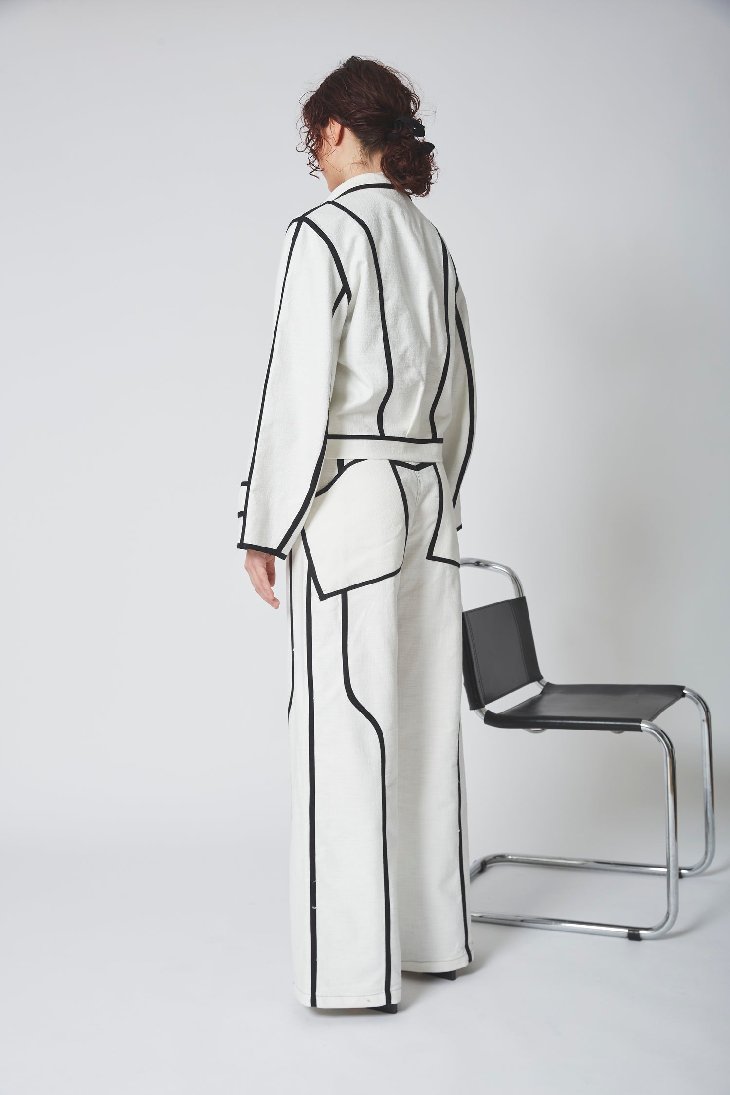 Femme portant l'ensemble BIAIS NOIR, ensemble structurant avec silhouette dynamique et élancée.