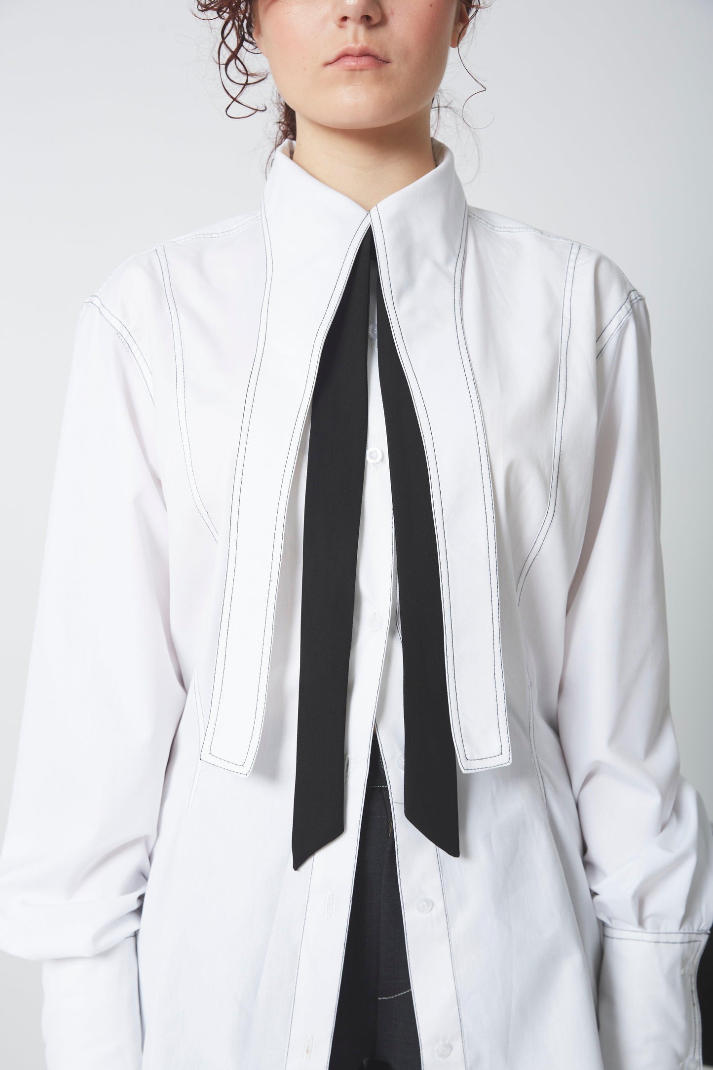 CHEMISE LIGNE FUYANTE, col démesuré, effet vertical, taille cintrée et découpe poitrine.