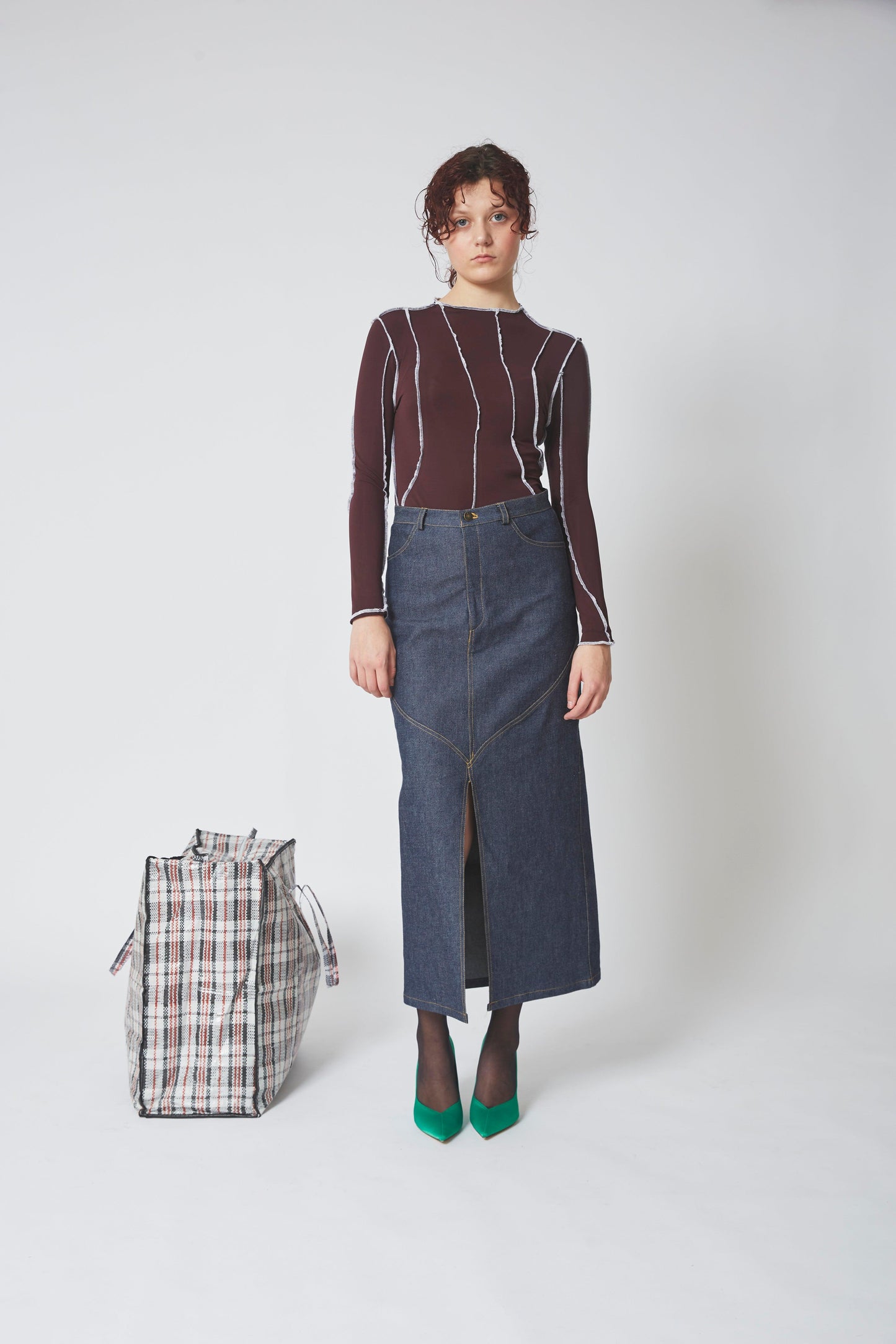 Femme portant la JUPE ADA et TOP SURJET aubergine, jean brut.