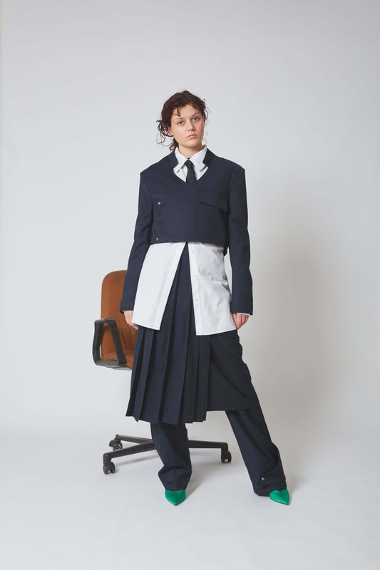 Femme portant la VESTE SHIMENAWA, lainage bleue marine, col Mao avec rabat asymétrique sur l’avant.