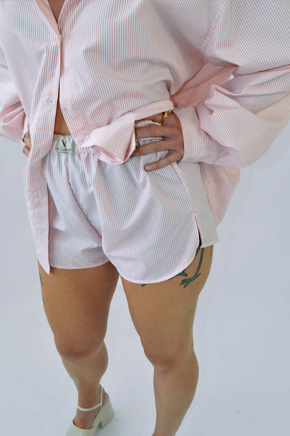 Femme portant le SHORT BLOOM rayé rose en coton, coupe boxer à taille élastique, assorti à la CHEMISE  TOC TOC ROSE ample pour un look confortable et élégant.