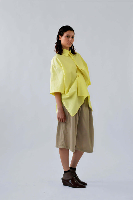 Femme portant le BERMUDA TRALALA SABLE en laine associé avec la chemise PAF JAUNE, coupe structurée et élégante.