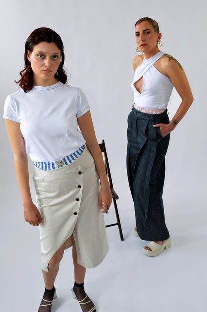 Deux femmes posant côte à côte : l’une porte le t-shirt moulant blanc à manches courtes, l’autre le débardeur blanc croisé avec surpiqûres bleues, montrant la versatilité de l’ensemble CLIC CLAC TOP.