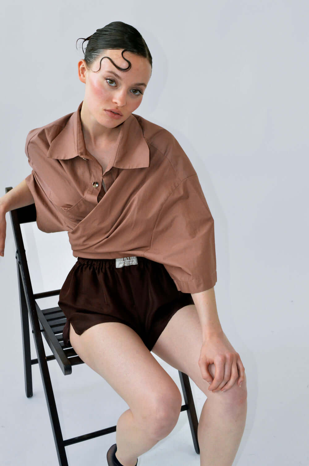 Femme vêtue de la chemise PAF PAF et du SHORT BLOOM en soie aubergine marron, coupe fluide et taille élastique visible.